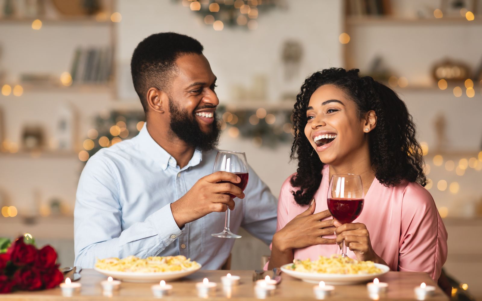 Couple laughing at a candlelit dinner